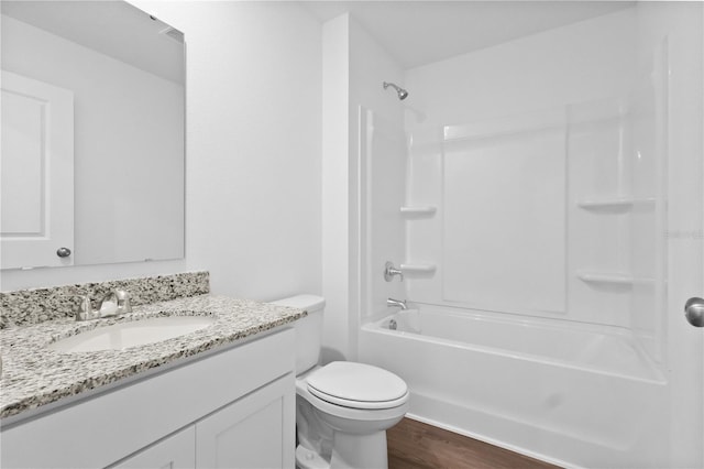 bathroom featuring toilet, shower / bathtub combination, wood finished floors, and vanity