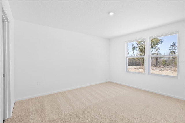 unfurnished room with light carpet and baseboards