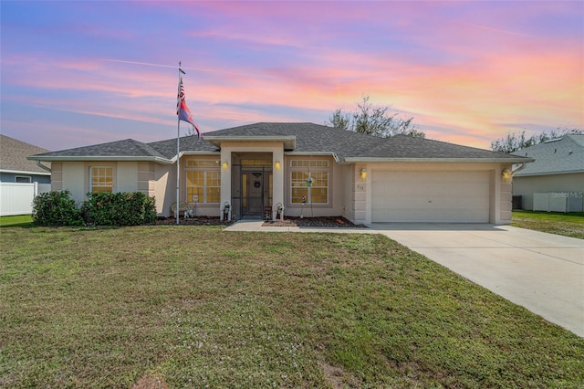 single story home with driveway, an attached garage, a lawn, and stucco siding