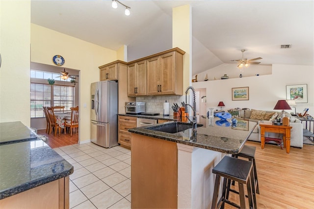 kitchen featuring ceiling fan, a peninsula, a sink, visible vents, and stainless steel fridge with ice dispenser