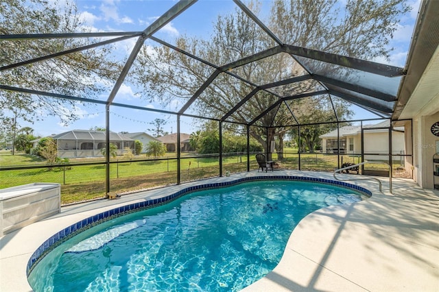 outdoor pool with a residential view, glass enclosure, a patio area, and a yard