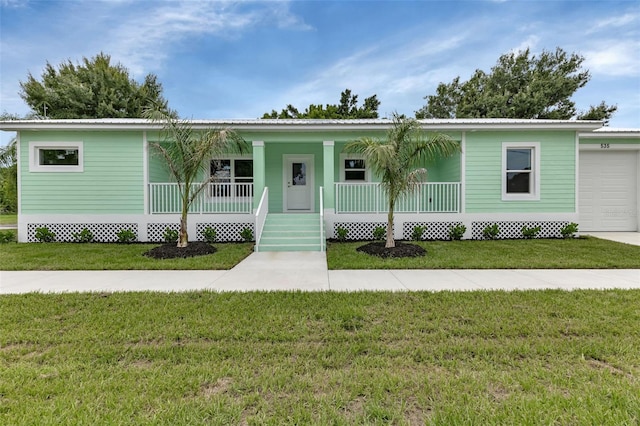 535 Milus St, Punta Gorda, FL 33950 - view of front of property featuring a porch, a front yard, metal roof, and a garage