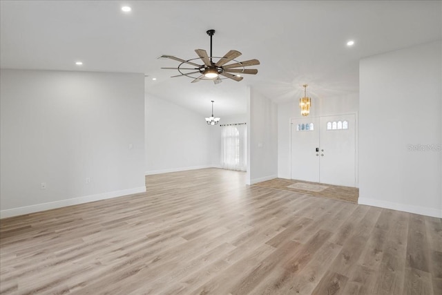 unfurnished living room with light wood-type flooring, baseboards, and lofted ceiling