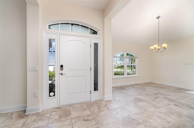 foyer entrance with baseboards and a notable chandelier