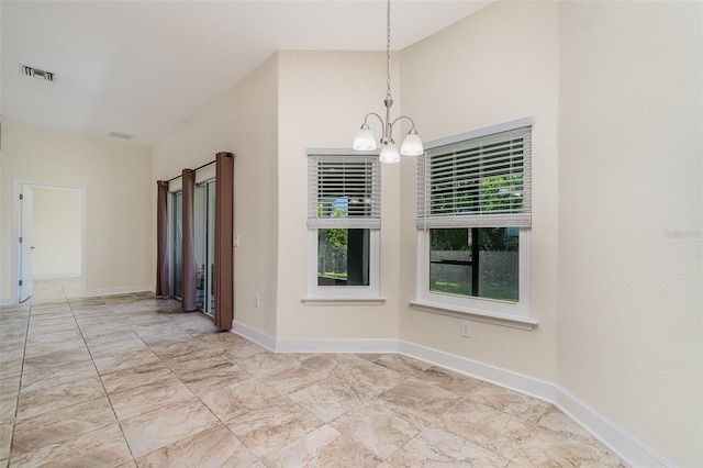 spare room with a chandelier, visible vents, and baseboards