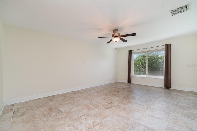 spare room featuring baseboards, visible vents, and a ceiling fan