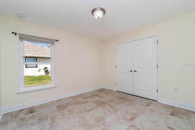 unfurnished bedroom featuring baseboards and a closet