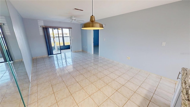 empty room featuring light tile patterned floors, ceiling fan, and visible vents