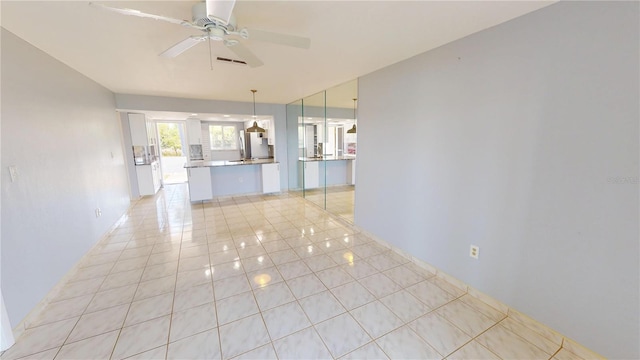 empty room featuring a ceiling fan, visible vents, and light tile patterned floors