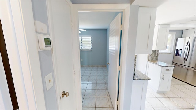 corridor featuring plenty of natural light and light tile patterned floors