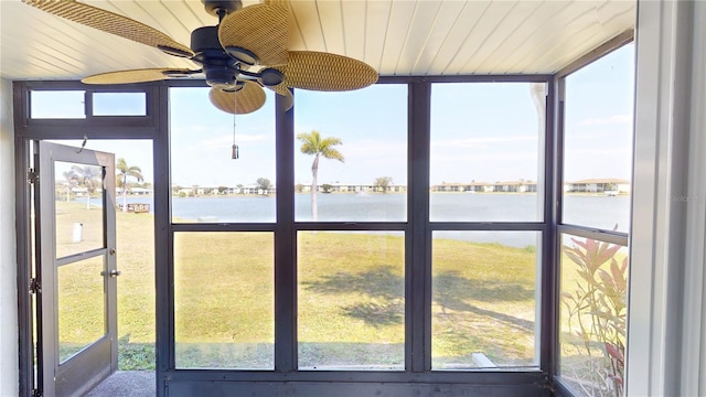 unfurnished sunroom with a ceiling fan, wooden ceiling, and a water view