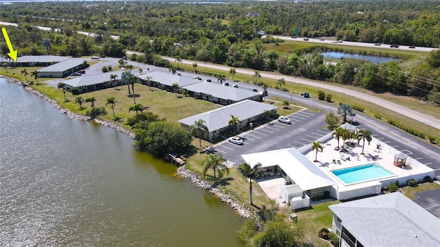 birds eye view of property featuring a water view and a view of trees