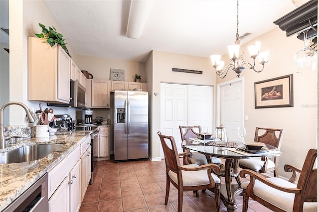 24321 Kintail Ct, Punta Gorda, FL 33980 - kitchen with light tile patterned floors, visible vents, a notable chandelier, a sink, and appliances with stainless steel finishes