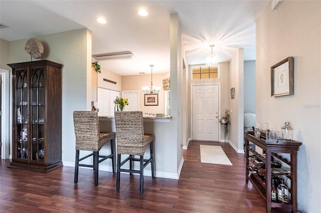 24321 Kintail Ct, Punta Gorda, FL 33980 - kitchen with dark wood-type flooring, baseboards, and a breakfast bar
