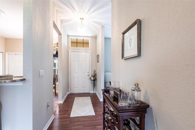 24321 Kintail Ct, Punta Gorda, FL 33980 - foyer with dark wood-style flooring, baseboards, and a textured wall