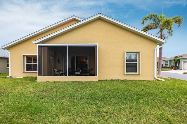 24321 Kintail Ct, Punta Gorda, FL 33980 - rear view of house featuring a yard, a sunroom, and stucco siding