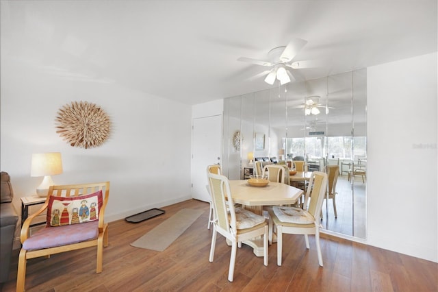 dining space with baseboards, wood finished floors, and a ceiling fan