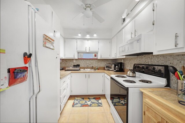 kitchen with backsplash, white cabinetry, white appliances, light countertops, and light tile patterned floors