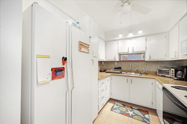 kitchen featuring electric range, freestanding refrigerator, a sink, decorative backsplash, and light countertops