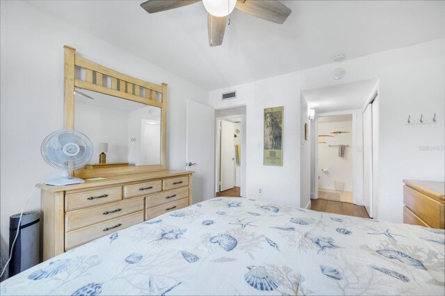 bedroom with ceiling fan, visible vents, and connected bathroom