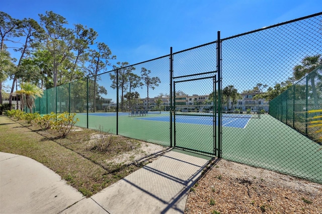 view of sport court with fence and a gate