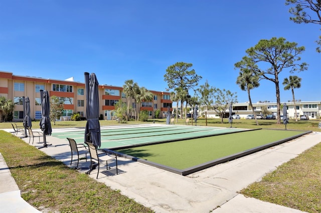 view of home's community with shuffleboard and a lawn