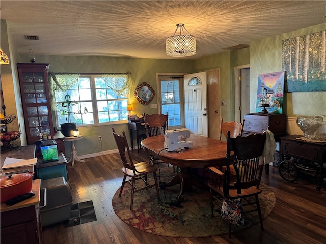 dining area with visible vents, baseboards, and hardwood / wood-style flooring