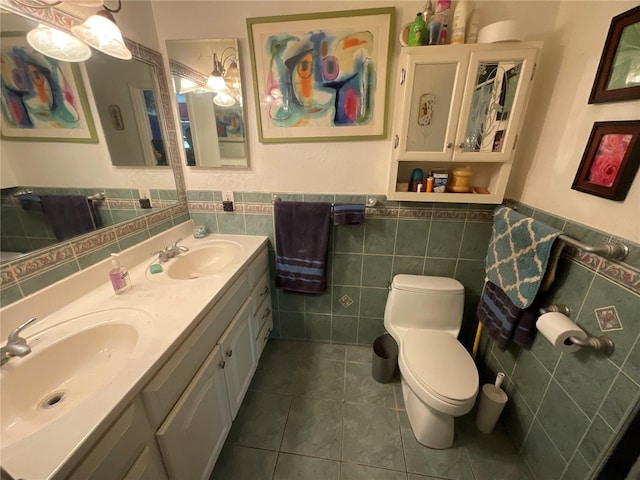 bathroom with double vanity, tile patterned flooring, a sink, and toilet