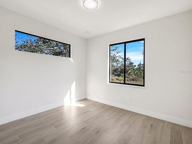 unfurnished room featuring light wood-type flooring and baseboards