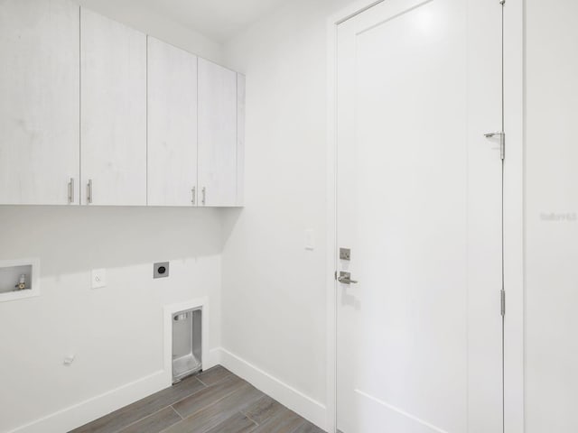 laundry area with hookup for an electric dryer, washer hookup, baseboards, cabinet space, and dark wood finished floors