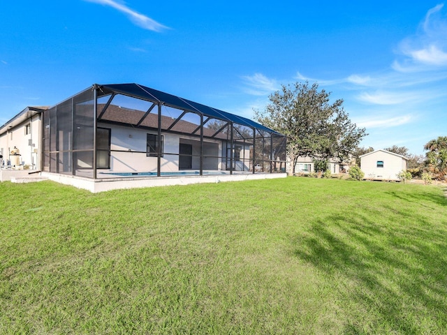 rear view of property with a lawn, a lanai, and an outdoor pool