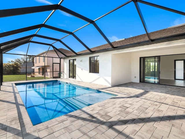 outdoor pool with a patio area and glass enclosure