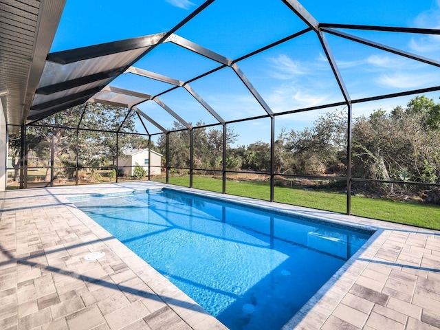 outdoor pool with a lanai, a patio, and a lawn