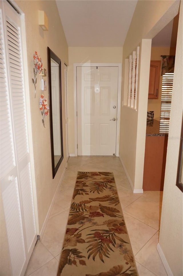 hallway featuring light tile patterned floors and baseboards