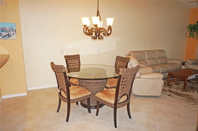 dining area featuring light tile patterned floors, a chandelier, and baseboards