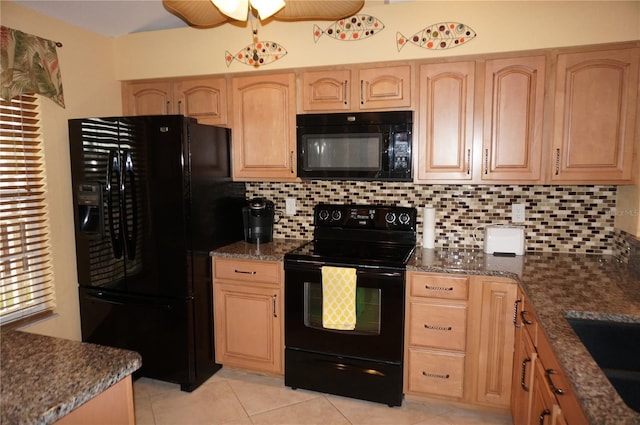 kitchen featuring black appliances, tasteful backsplash, dark stone counters, and light brown cabinetry