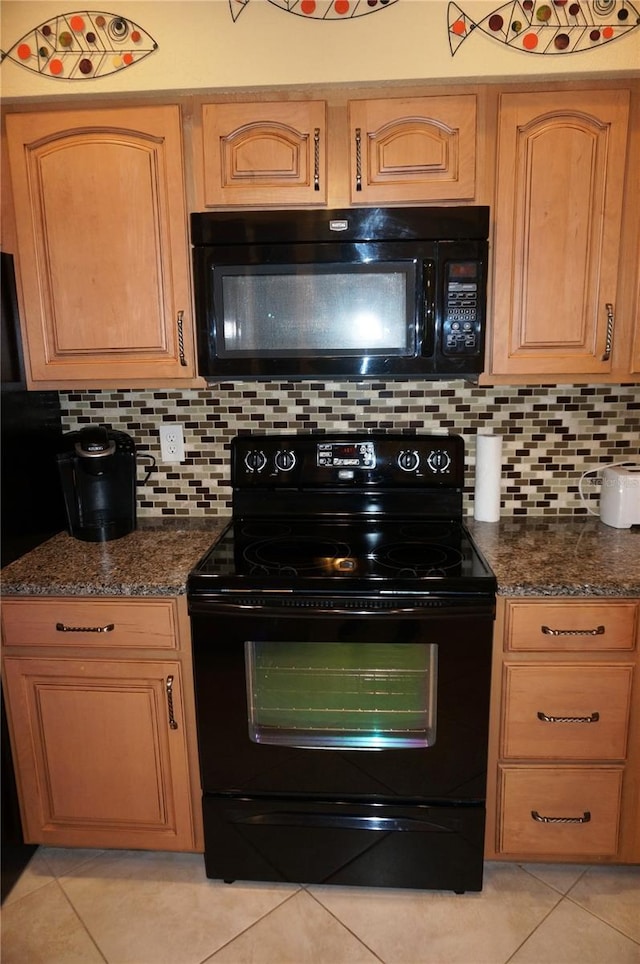 kitchen featuring dark stone counters, backsplash, black appliances, and light tile patterned floors