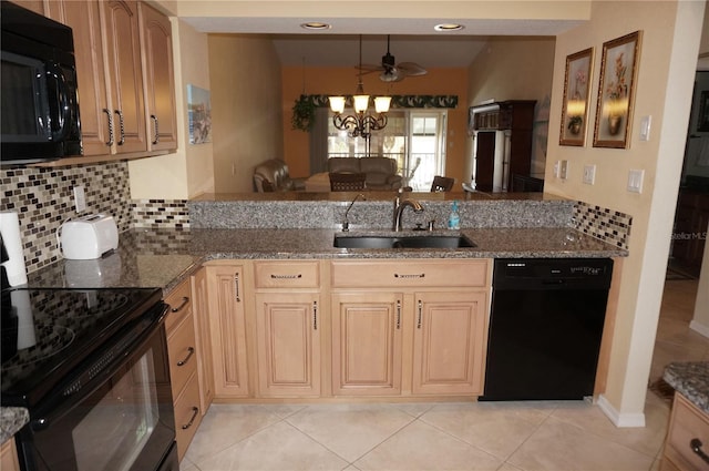 kitchen featuring black appliances, dark stone countertops, and a sink