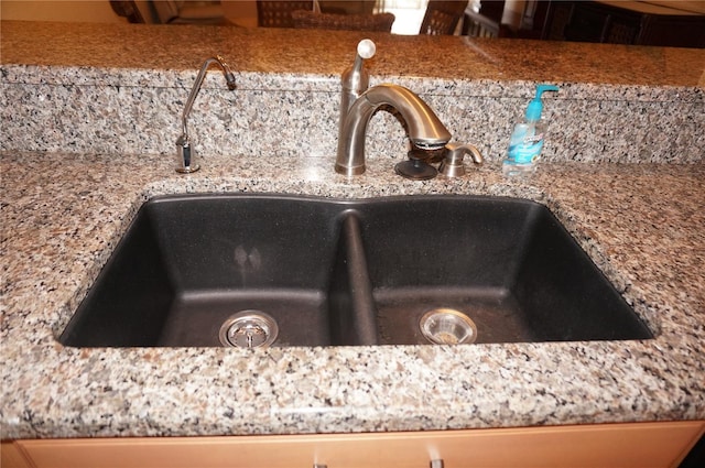 room details featuring light stone counters and a sink