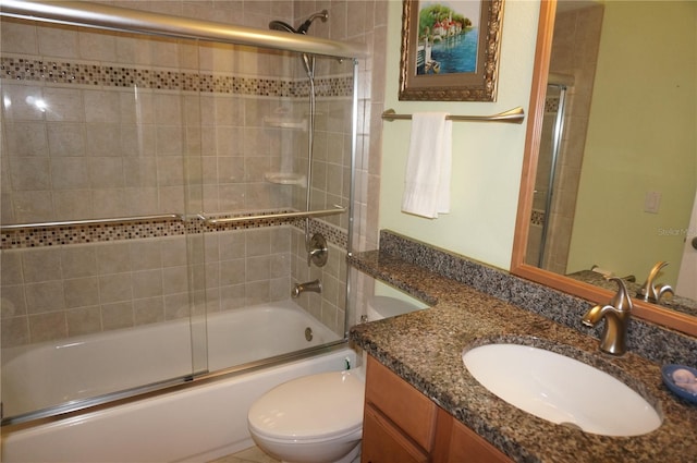 full bathroom featuring vanity, toilet, and bath / shower combo with glass door