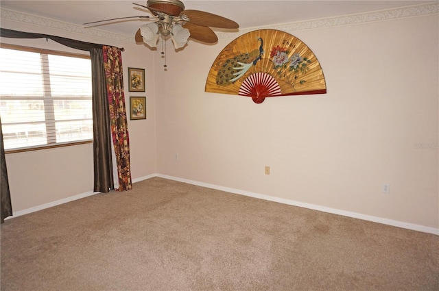 spare room with carpet floors, baseboards, and a ceiling fan