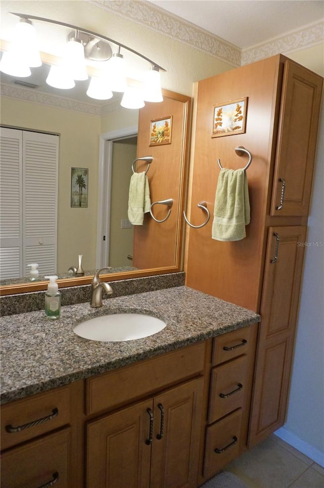 bathroom with crown molding, vanity, and tile patterned floors