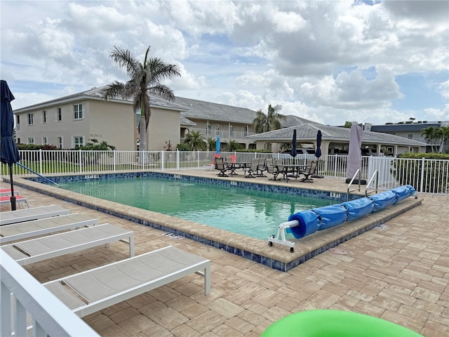 pool with a patio area and fence