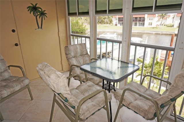 sunroom featuring a water view