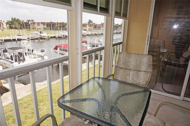 balcony with outdoor dining space and a water view