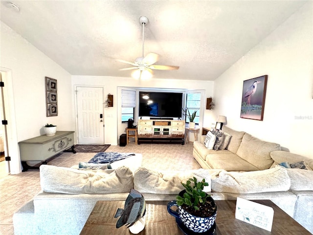 living room with lofted ceiling, tile patterned flooring, a textured ceiling, and a ceiling fan