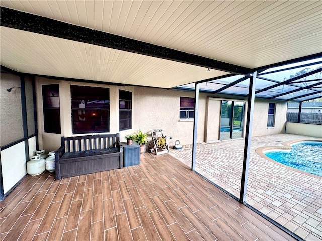 exterior space featuring glass enclosure, an outdoor pool, and a patio