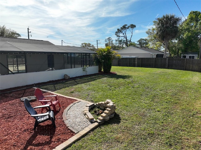 view of yard featuring fence private yard, glass enclosure, and an outdoor fire pit