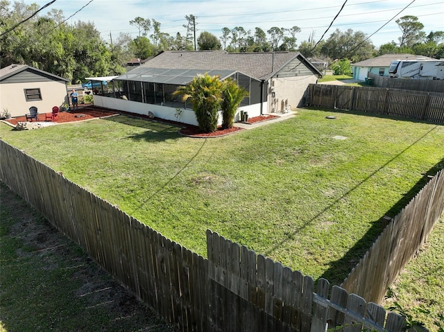 view of yard featuring a fenced backyard and a lanai