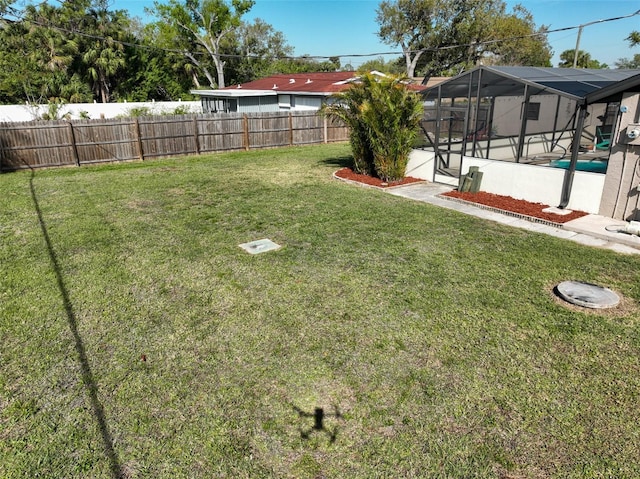 view of yard with a fenced in pool, a lanai, and a fenced backyard